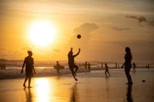 mensen spelen met bal op strand